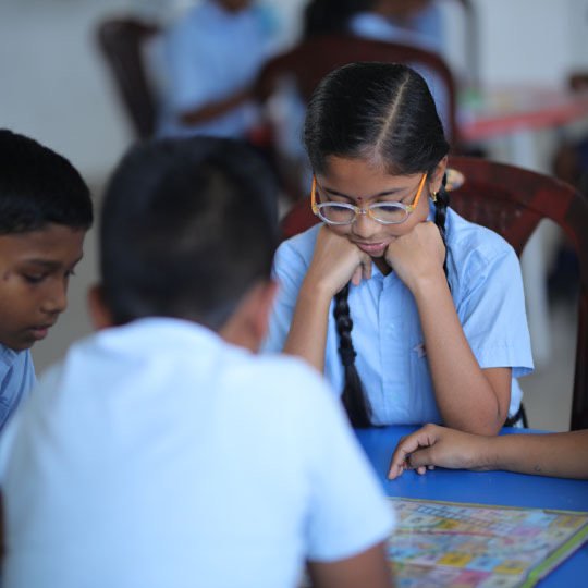 Bellwether students concentrating on a board game together