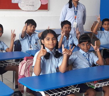 Bellwether students smiling together at their classroom desks
