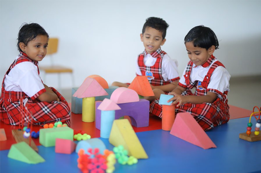 Young children exploring colourful building blocks in a Bellwether classroom