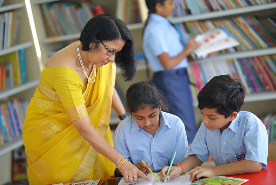 A teacher guiding students through books in the Bellwether library